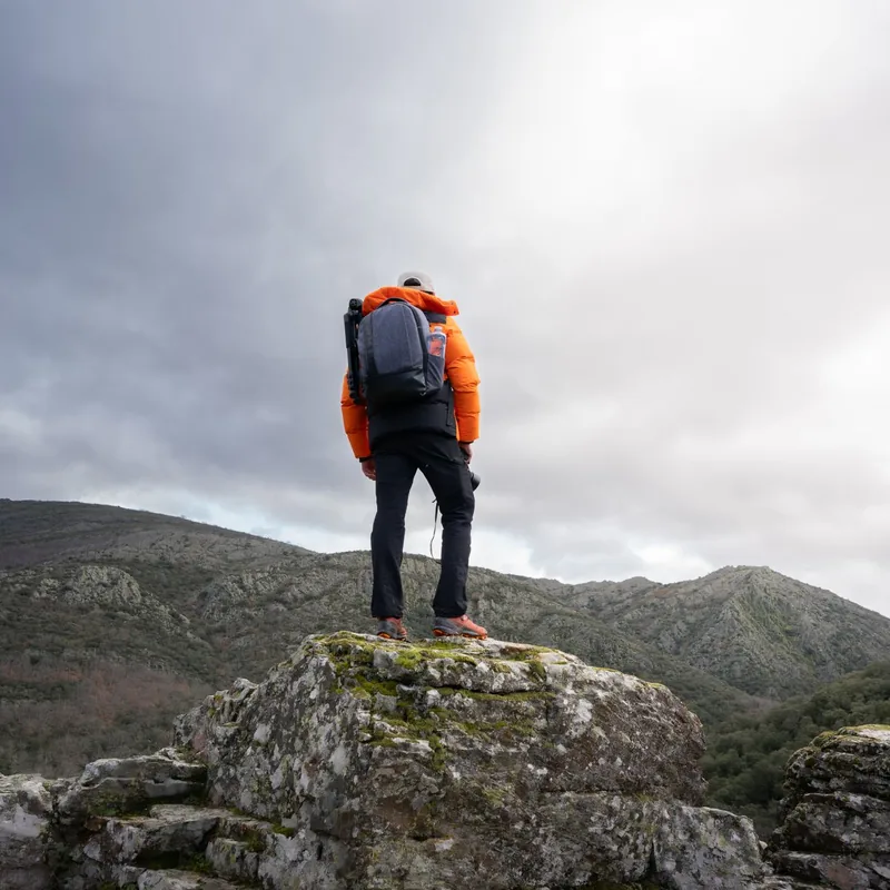 A Himalayan trek guide standing on a mountain trail with a backpack